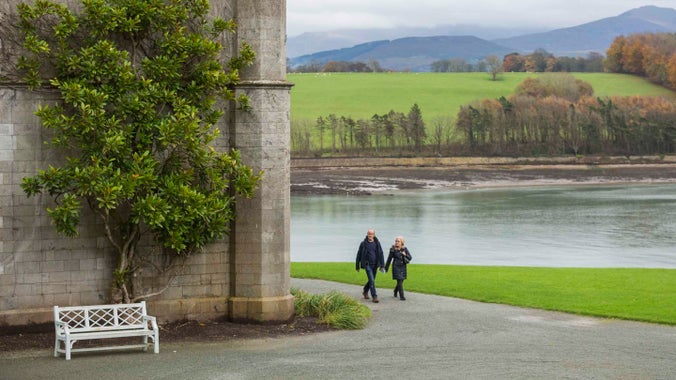 Couple walking in the garden at Plas Newydd with mountains in the background